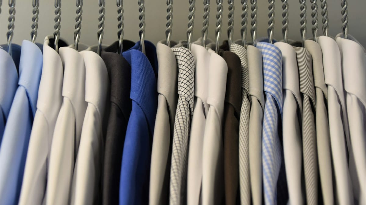 A coordinated work wardrobe — shirts organized by color for effortless combinations
